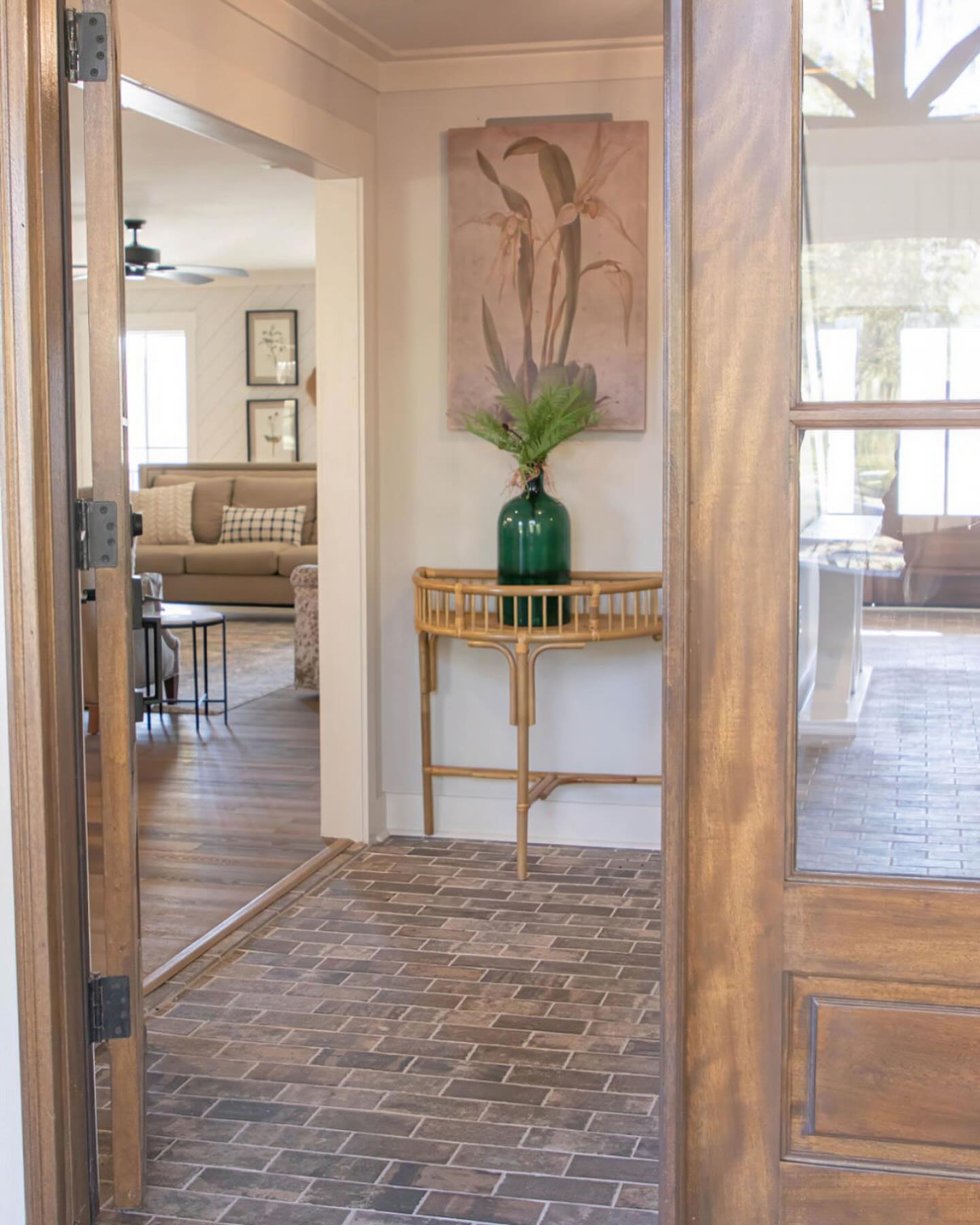 Foyer renovation by Tin Lily Design, features green vase on accent table with brick paver accent flooring.